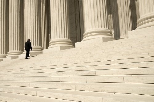 tall tan steps and columns in front of a court house