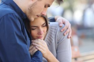 man comforting woman