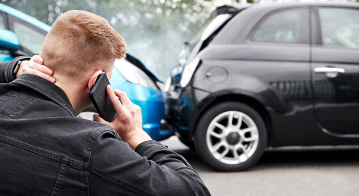 Man calling his insurance company after a car accident